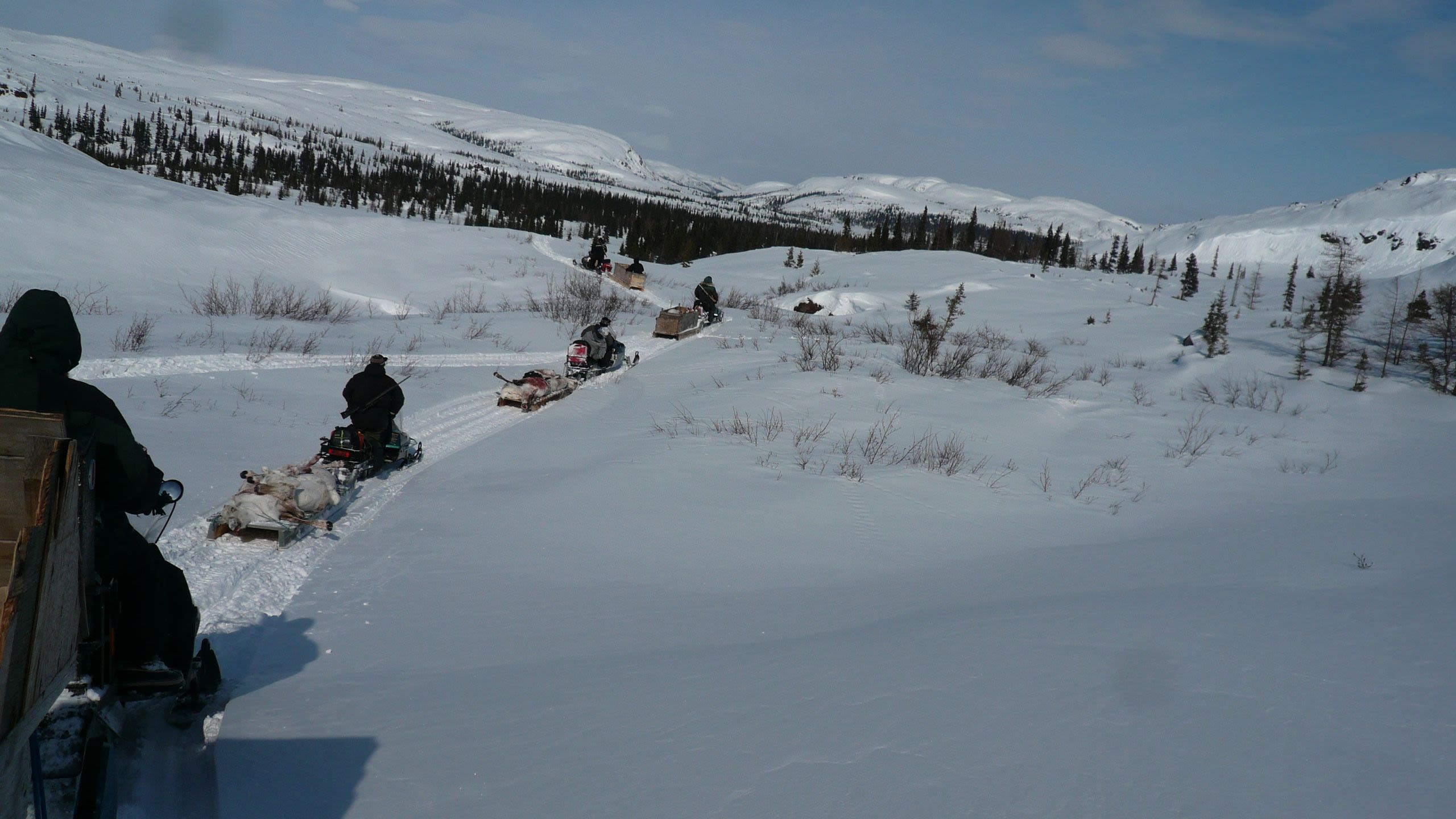 Group photo of Innu people on their motor sledges