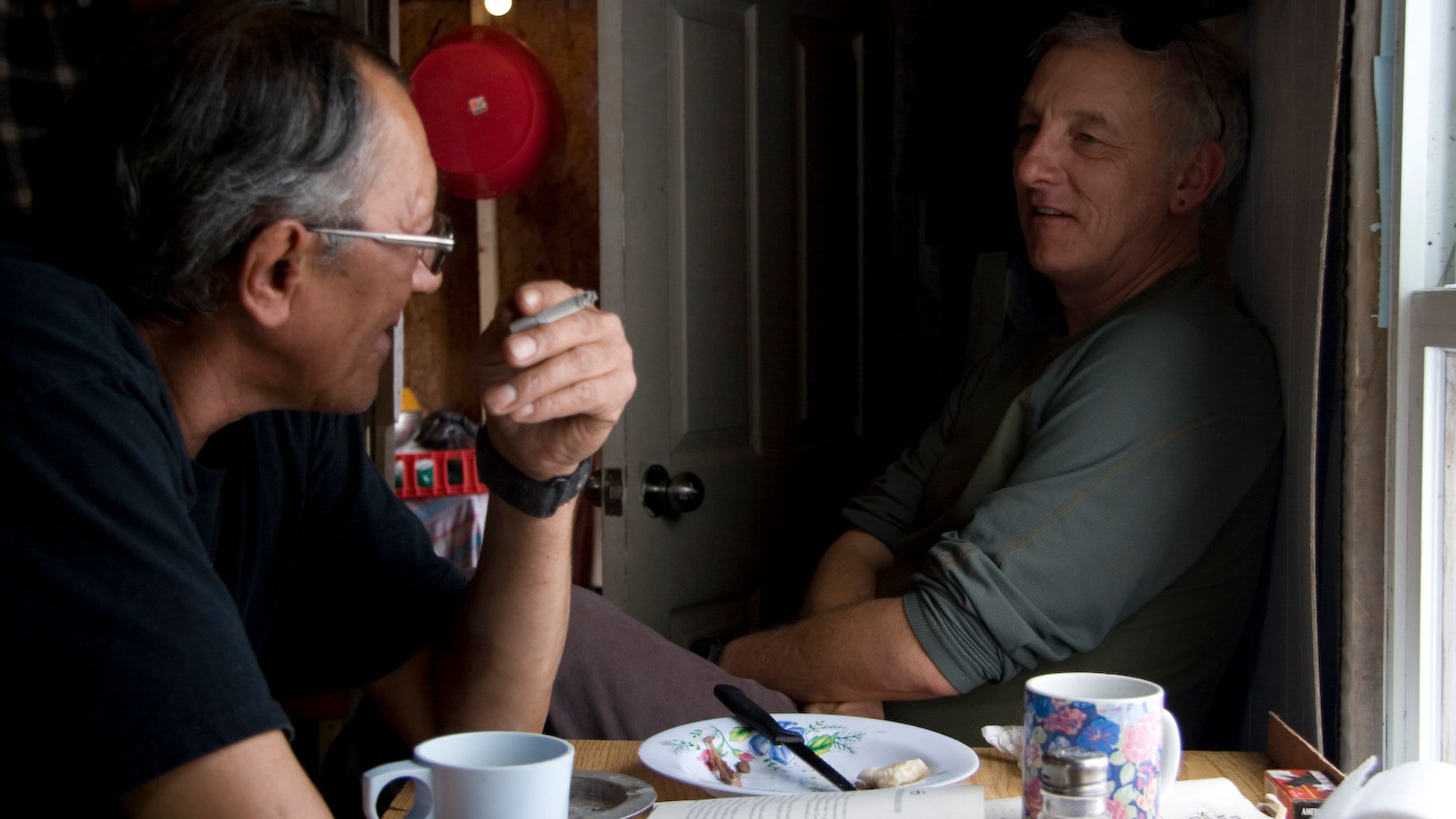 Colin Samson sitting inside chatting to Innu man