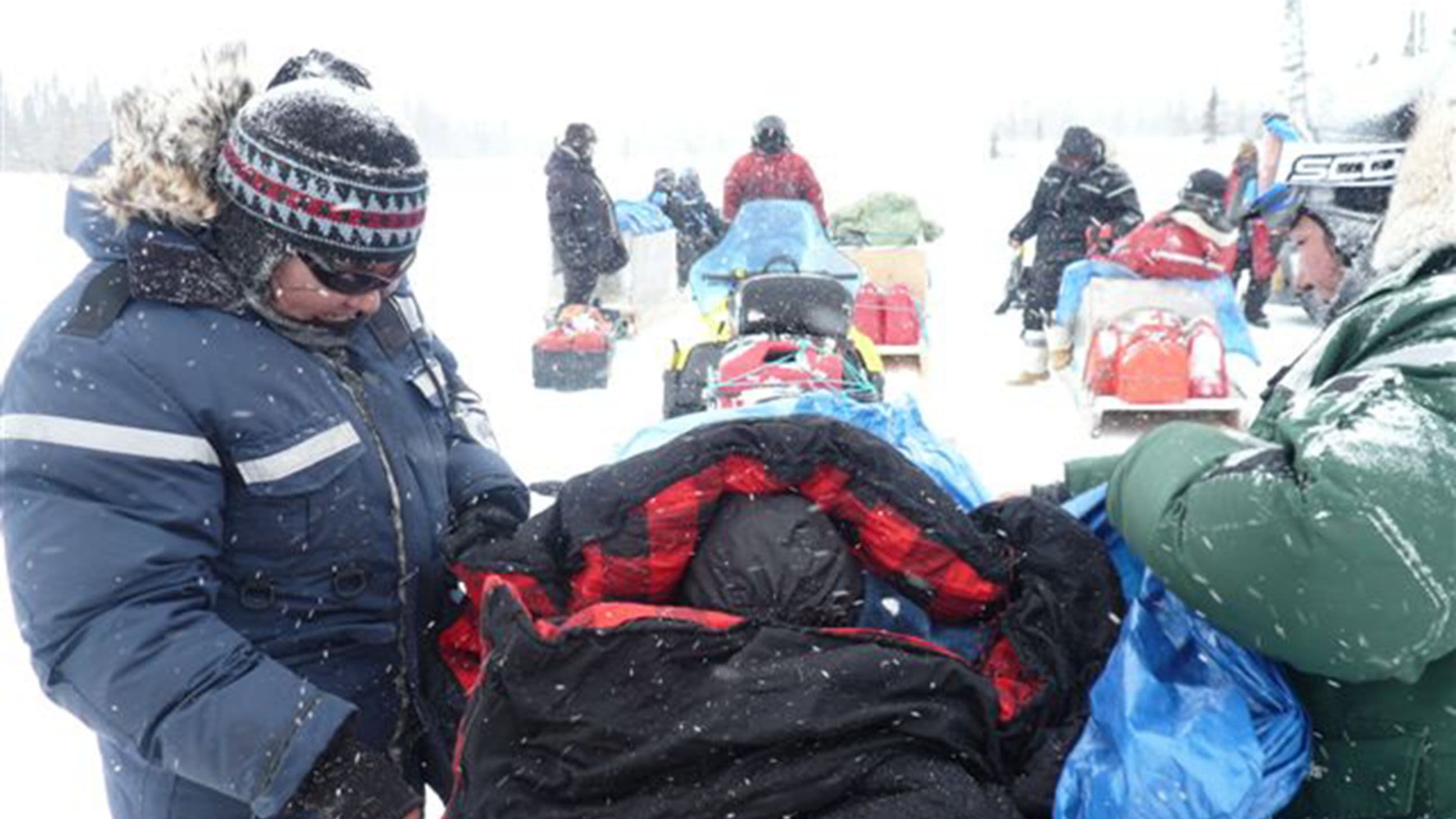 Innu man packing sledge in blizzard