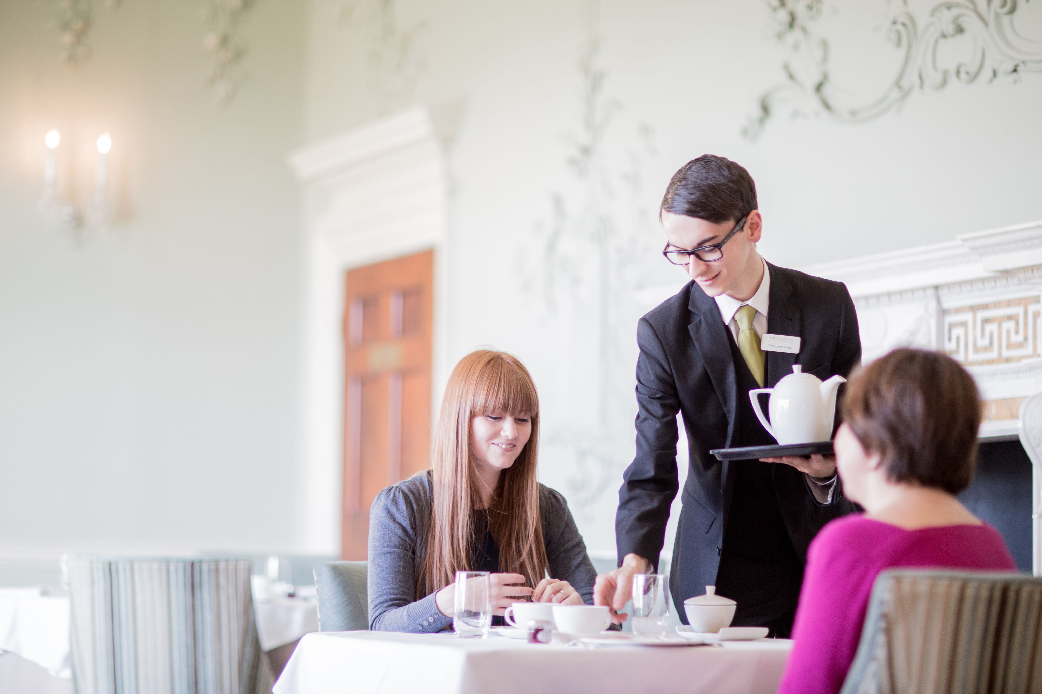 A young hospitality professional serves afternoon tea