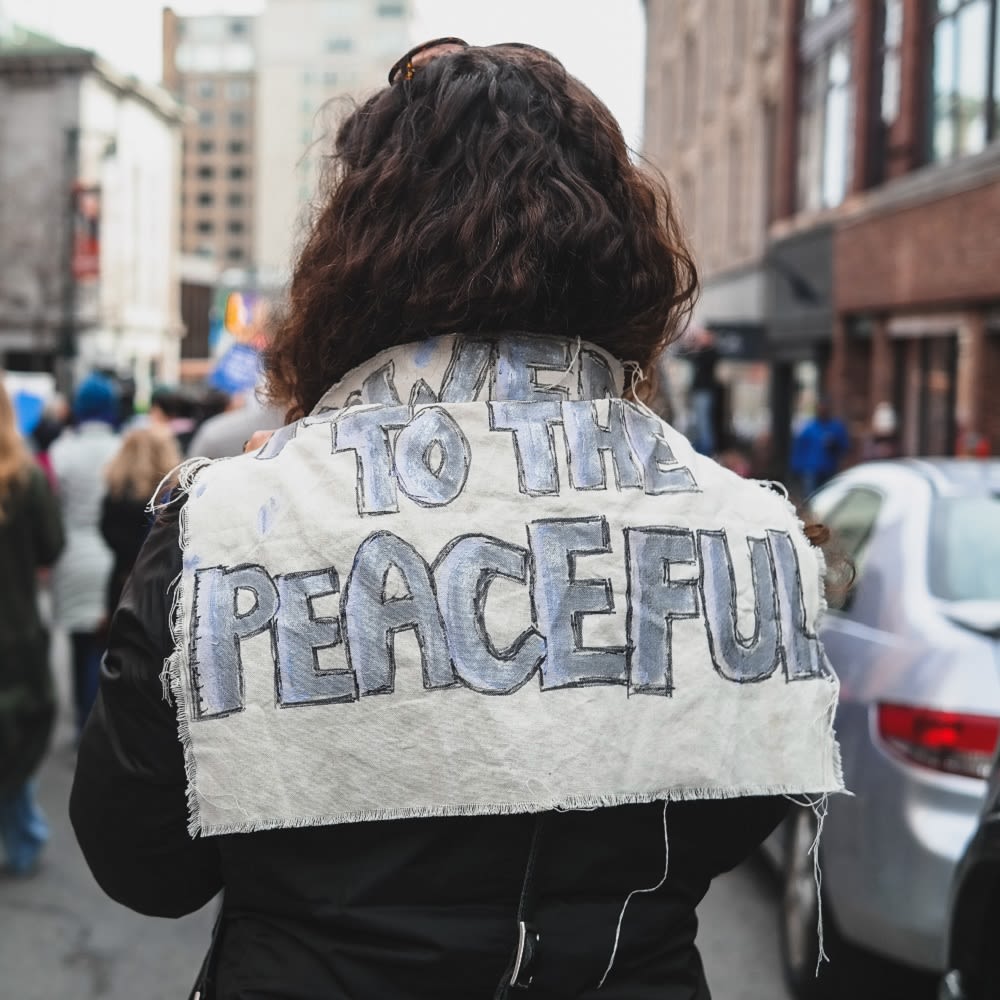 Activist with a sign on their back