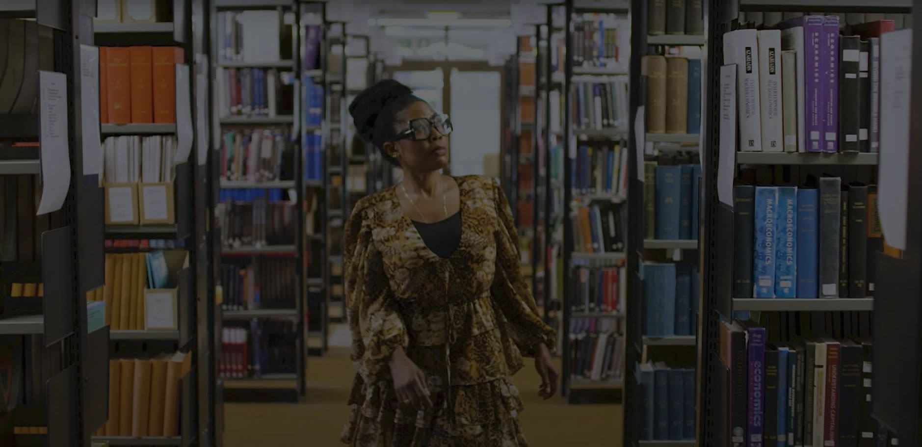 PhD Researcher Happiness walking through the library