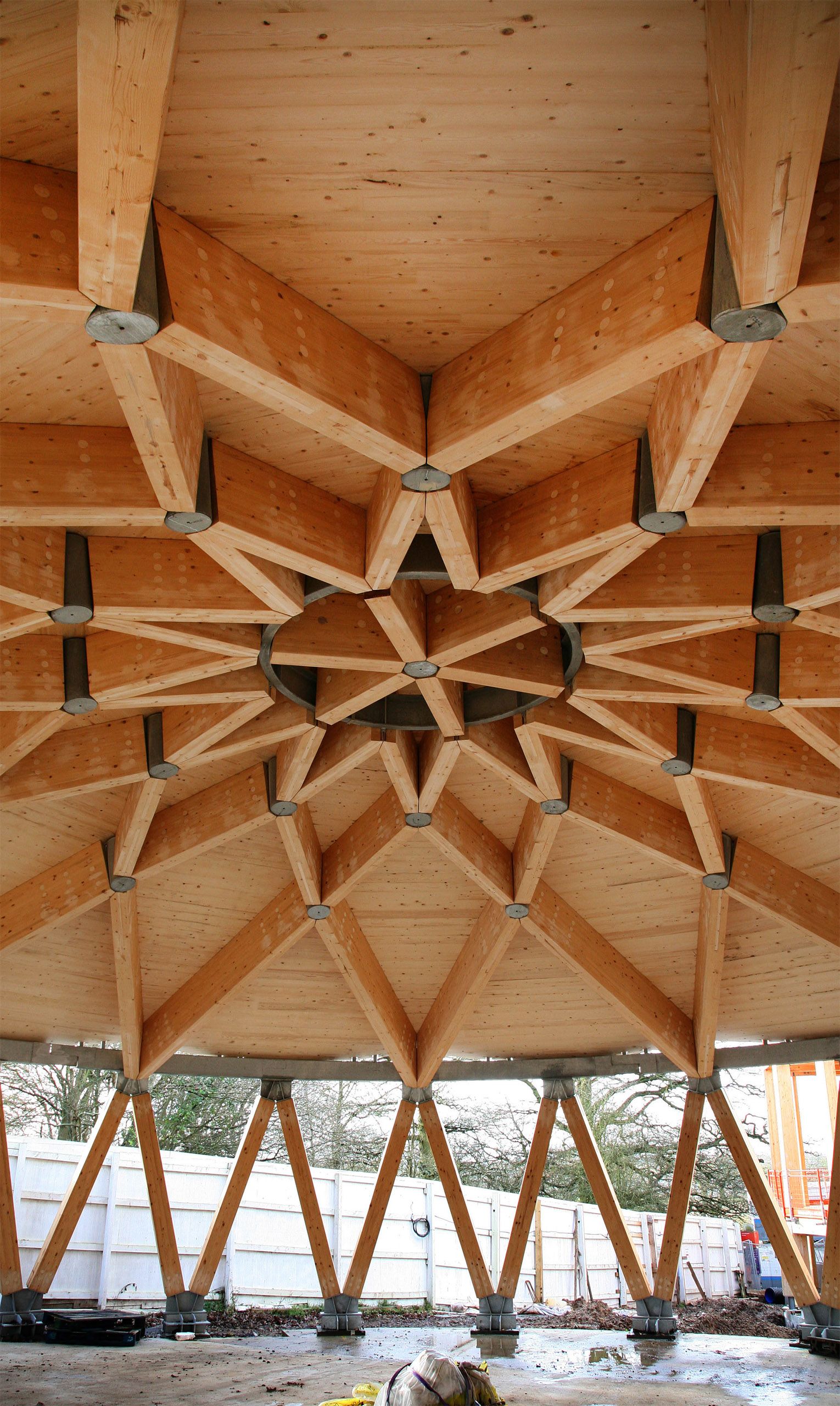 The completed roof beams of the main lecture theatre form a star pattern while its outside walls remain open to the elements.