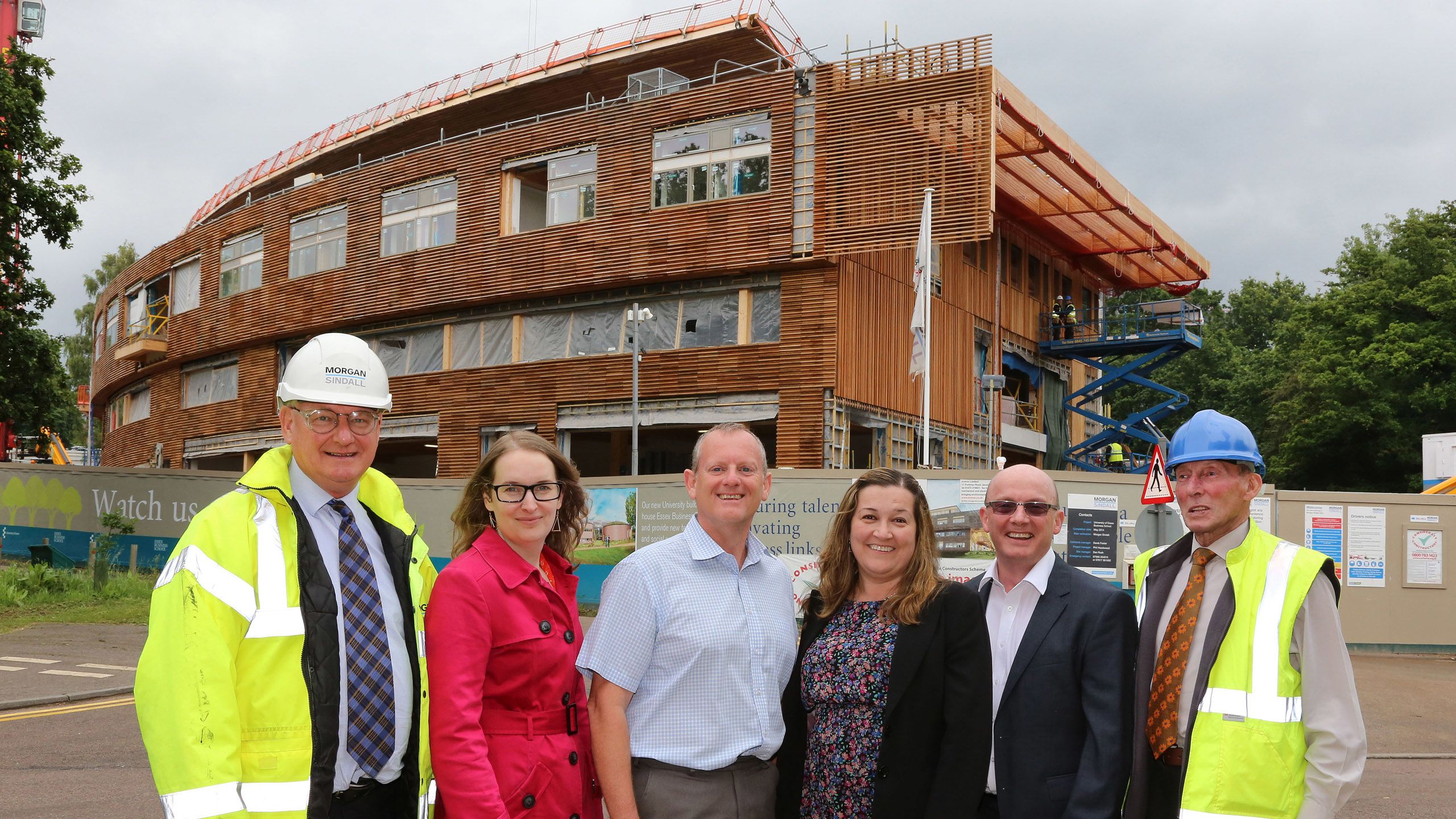 The Estates team smile outside a nearly-completed Essex Business School.
