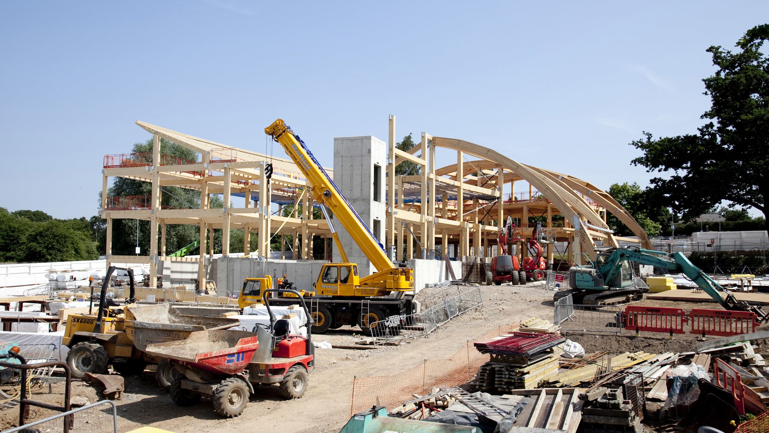Construction vehicles outside EBS' incomplete wooden frame.
