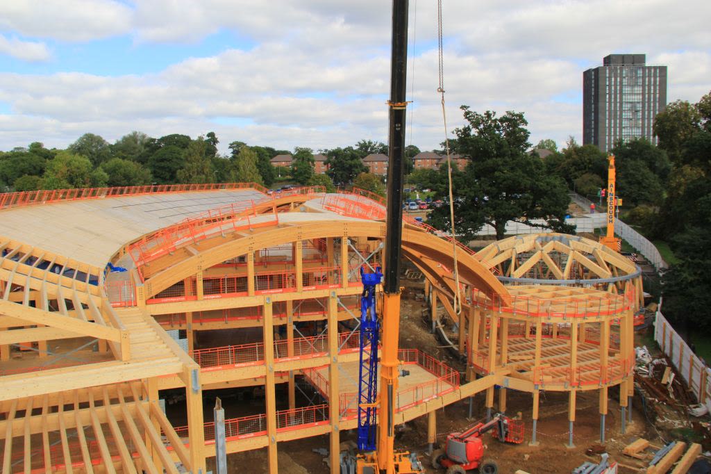 Cranes assemble the wooden frame of EBS while the Towers are visible in the background.
