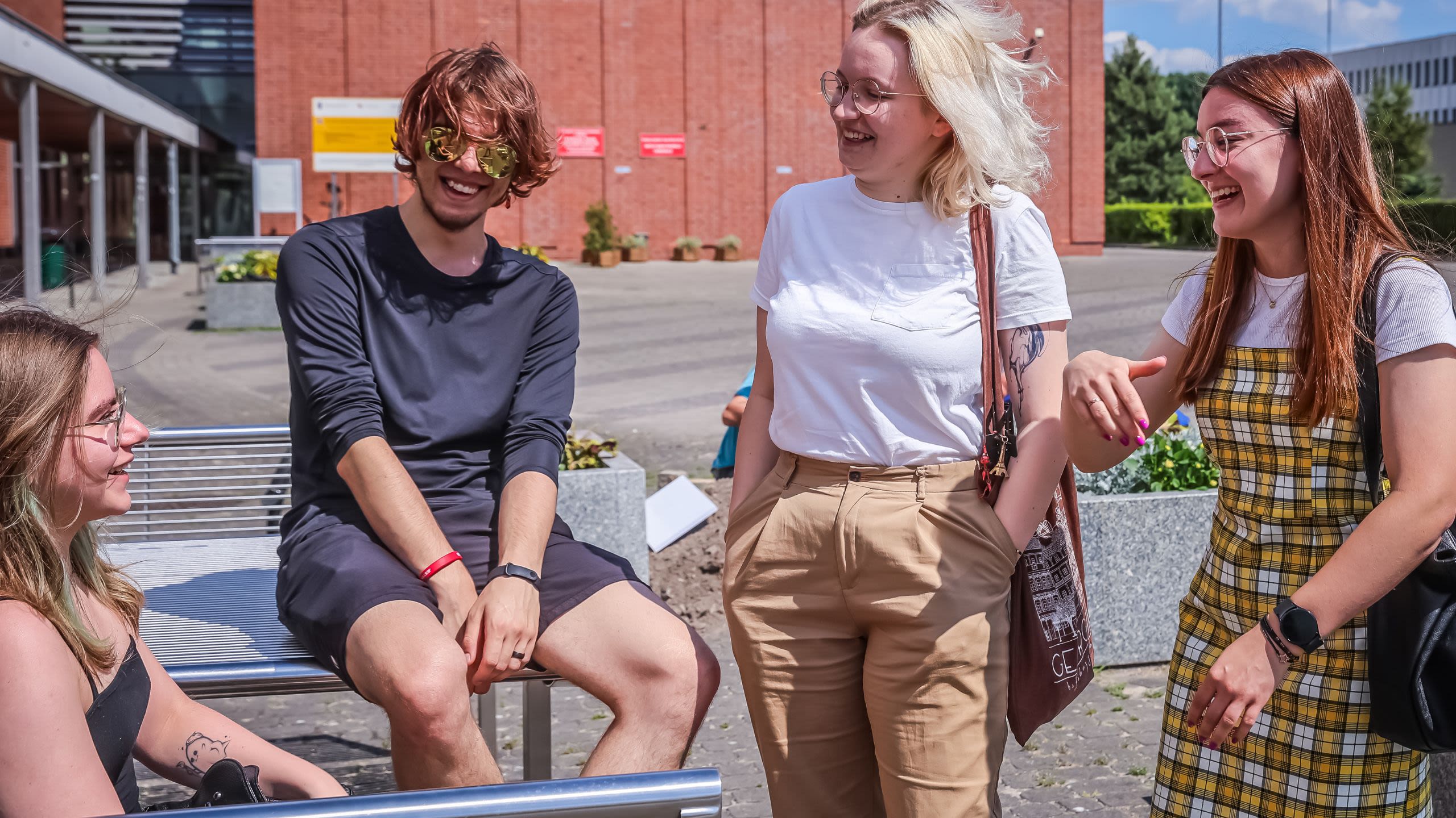 Four students chatting together in the sunshine