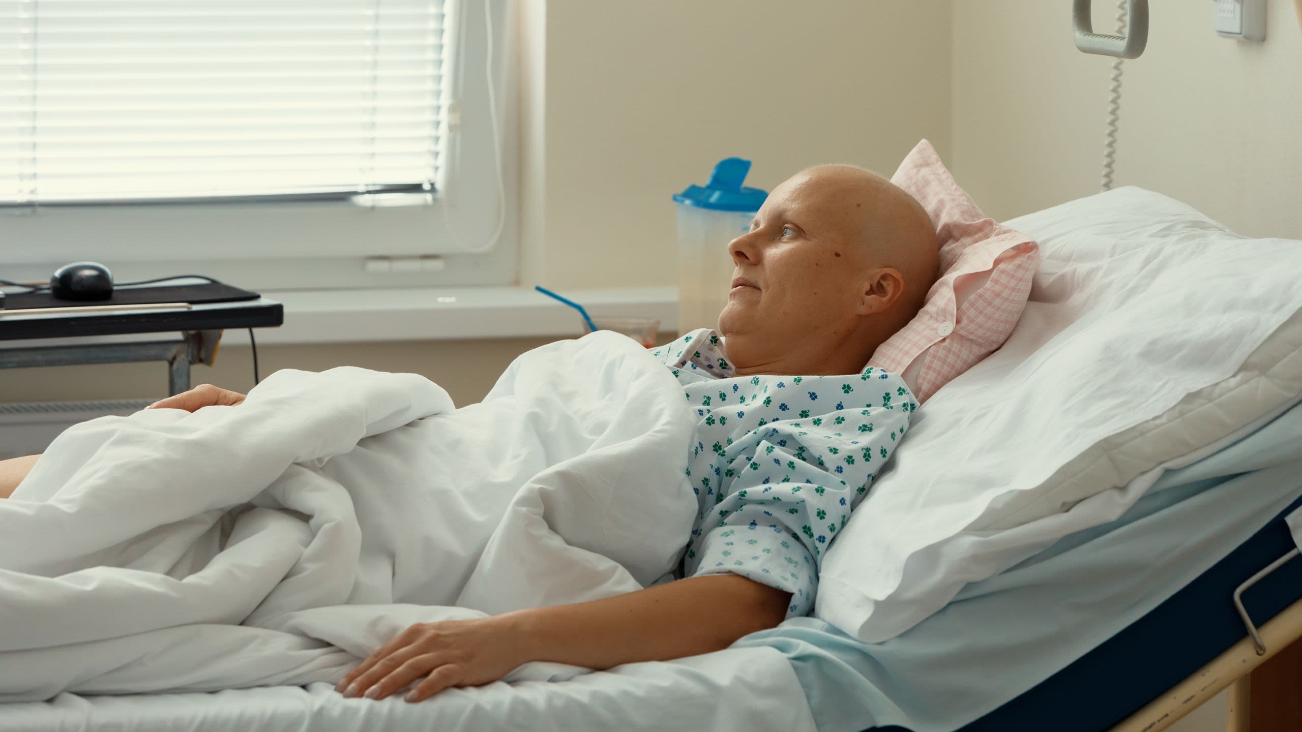 Woman who has lost her hair lying in hospital bed