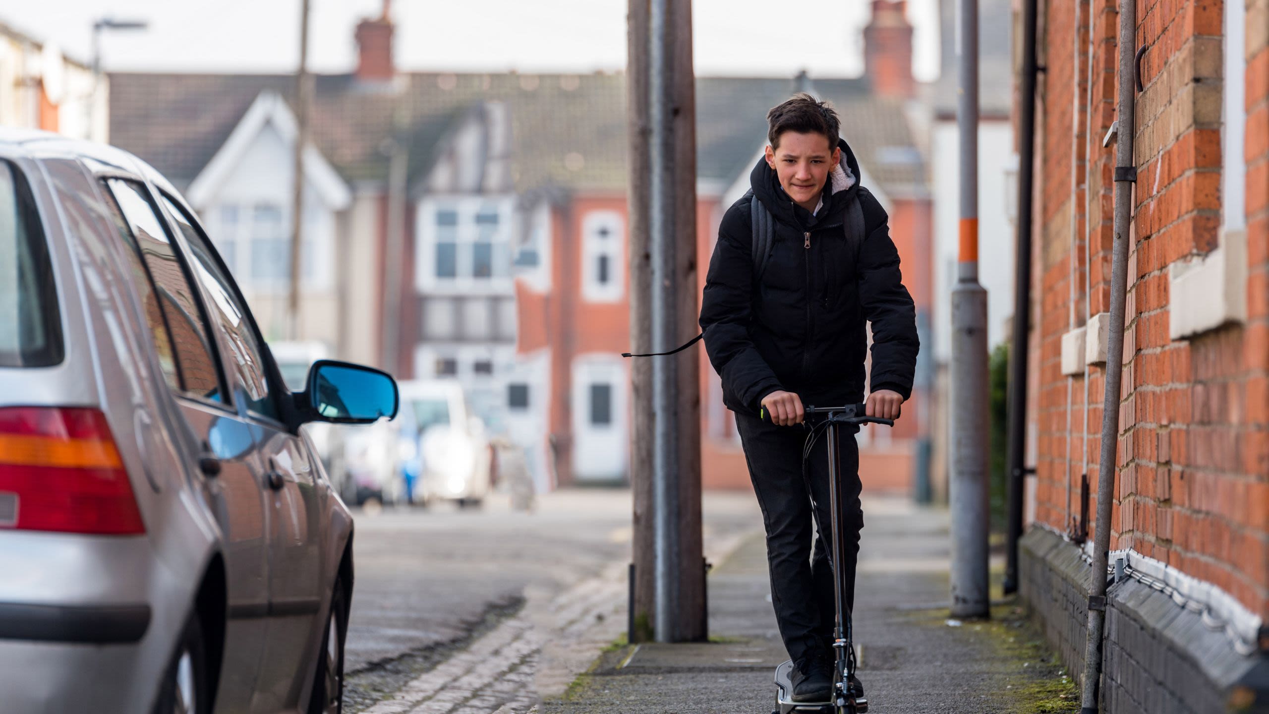 Young boy on scooter in residential area