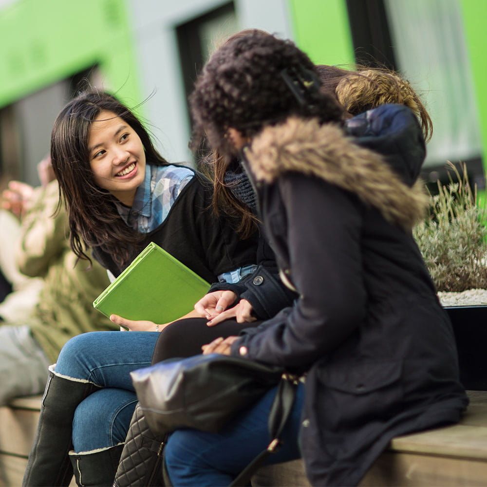 Students sitting down looking at a book