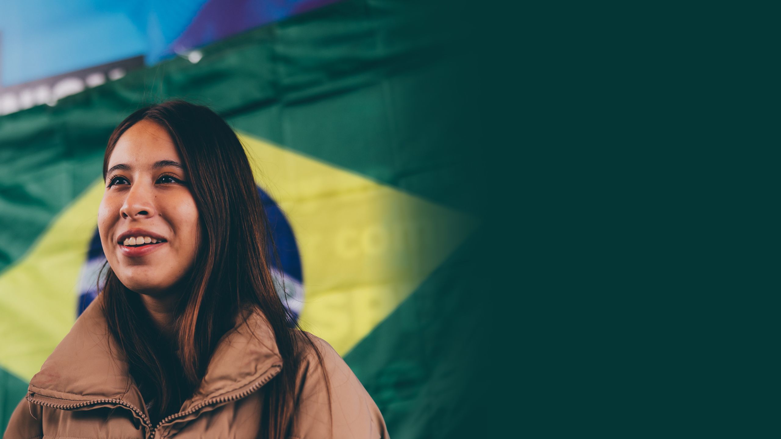 Student standing in front of a Brazilian flag