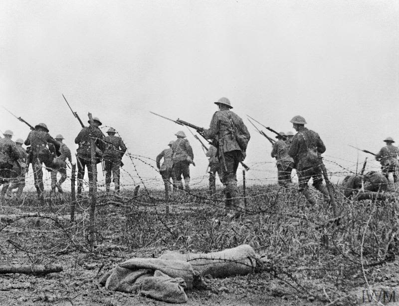 Archive photo of First World War troops, holding rifles, going over the top of the trenches