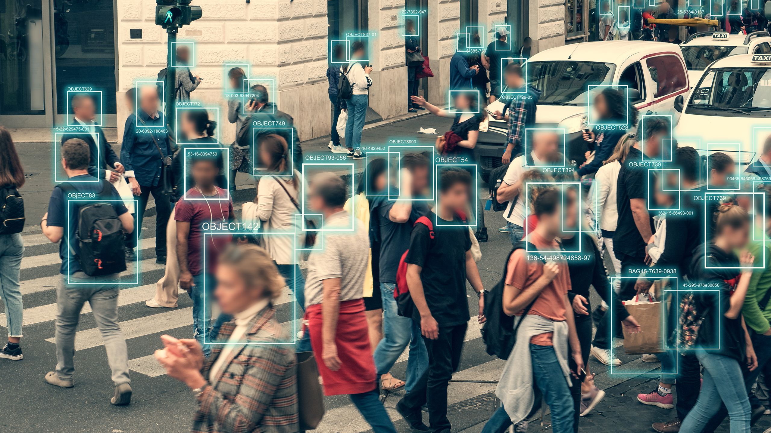 People walking across road with live facial technology being used to map their faces