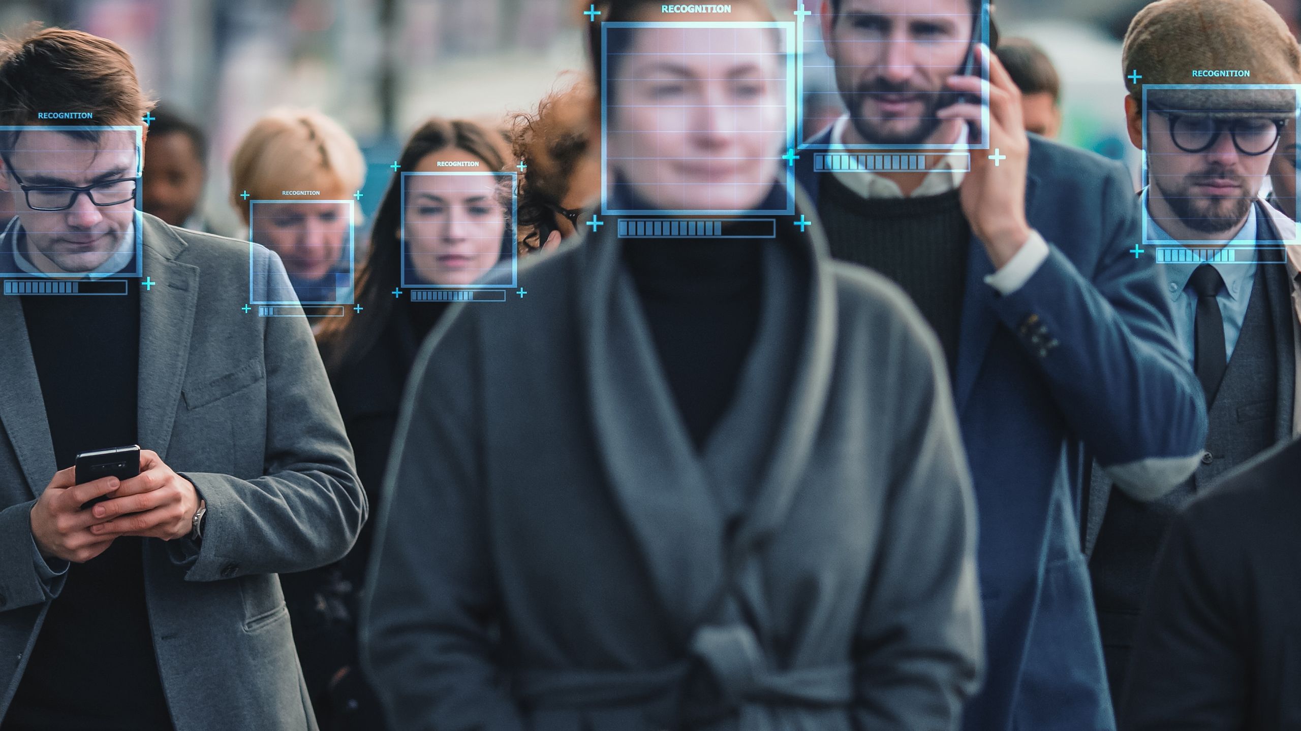 People walking along road with live facial technology being used to map their faces