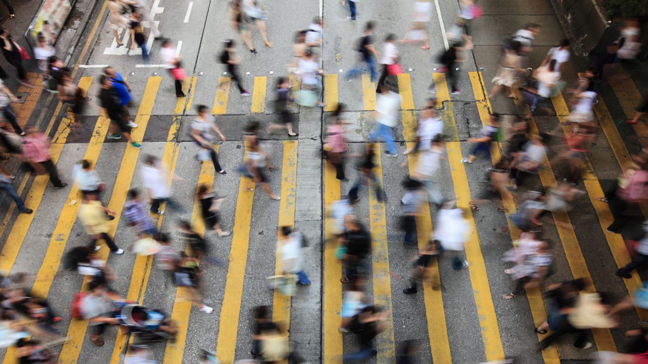 A crowd crossing a road in a busy city
