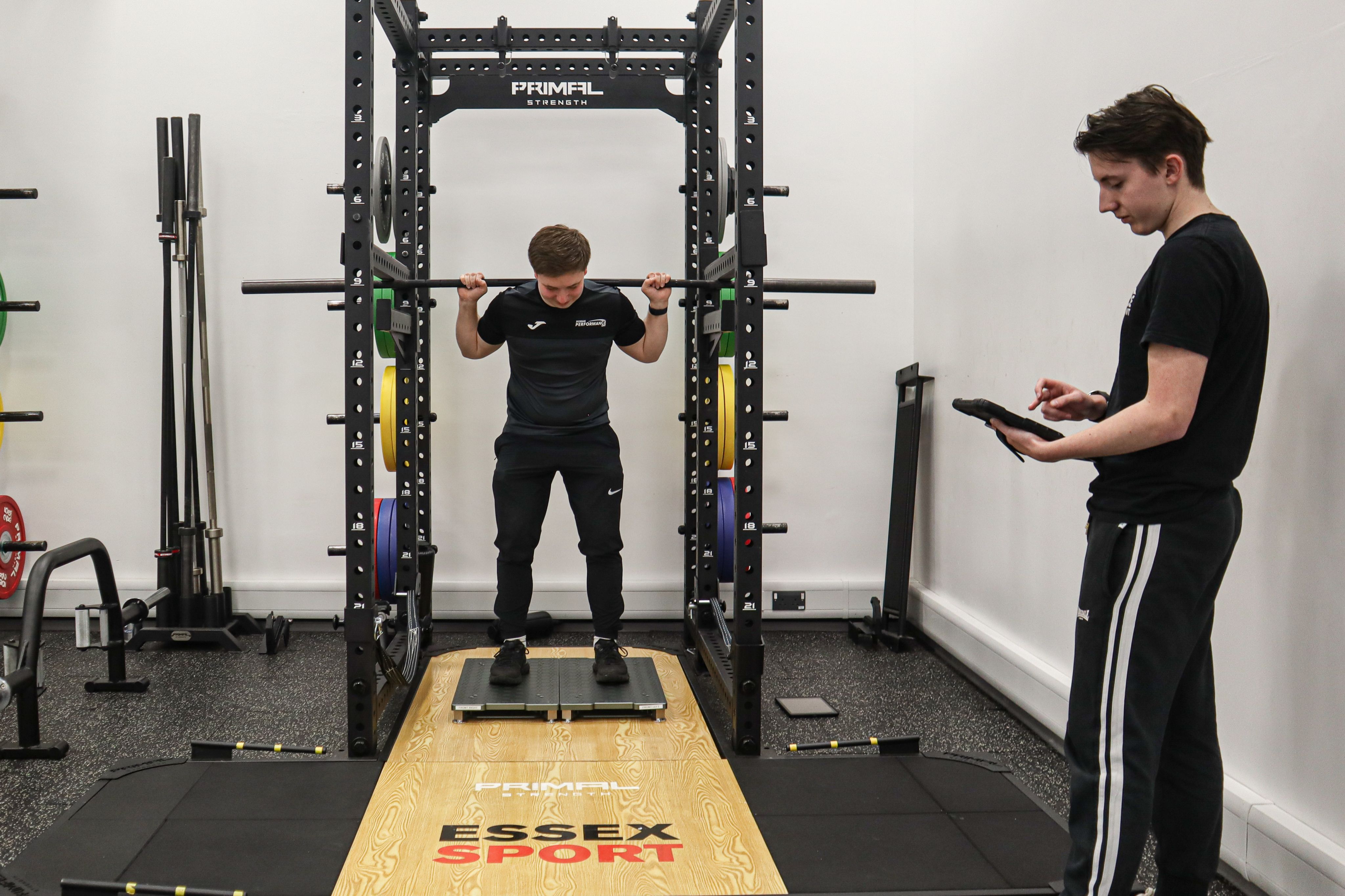 A sports science studying measuring an athlete on a weight rack