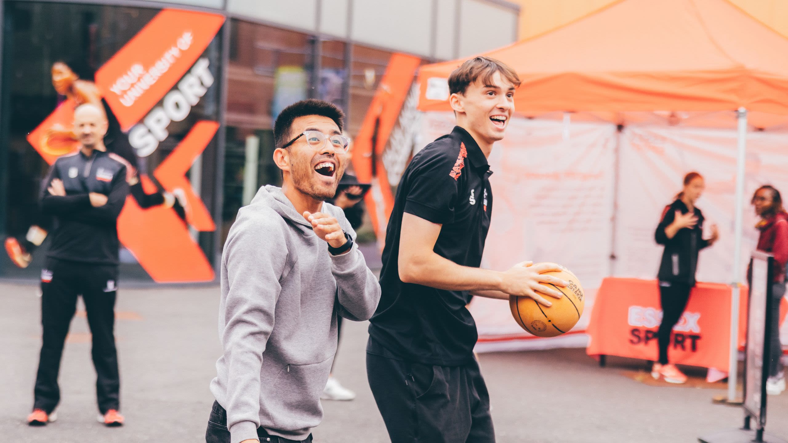 Six actors, wearing a mixture of vintage 20th century costumes on stage, one standing on a table and gesticulating wildly.