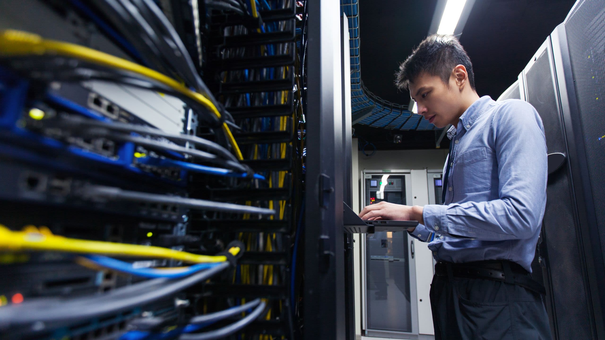 Man working on keyboard in data centre