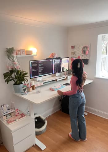 Liv working at her desk at home. The desk has double screens and lots of tech accessories to make it pretty