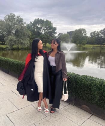 Liv is dressed in graduation robs, stood next to her sister with her arm around her. They are looking at each other's with affection